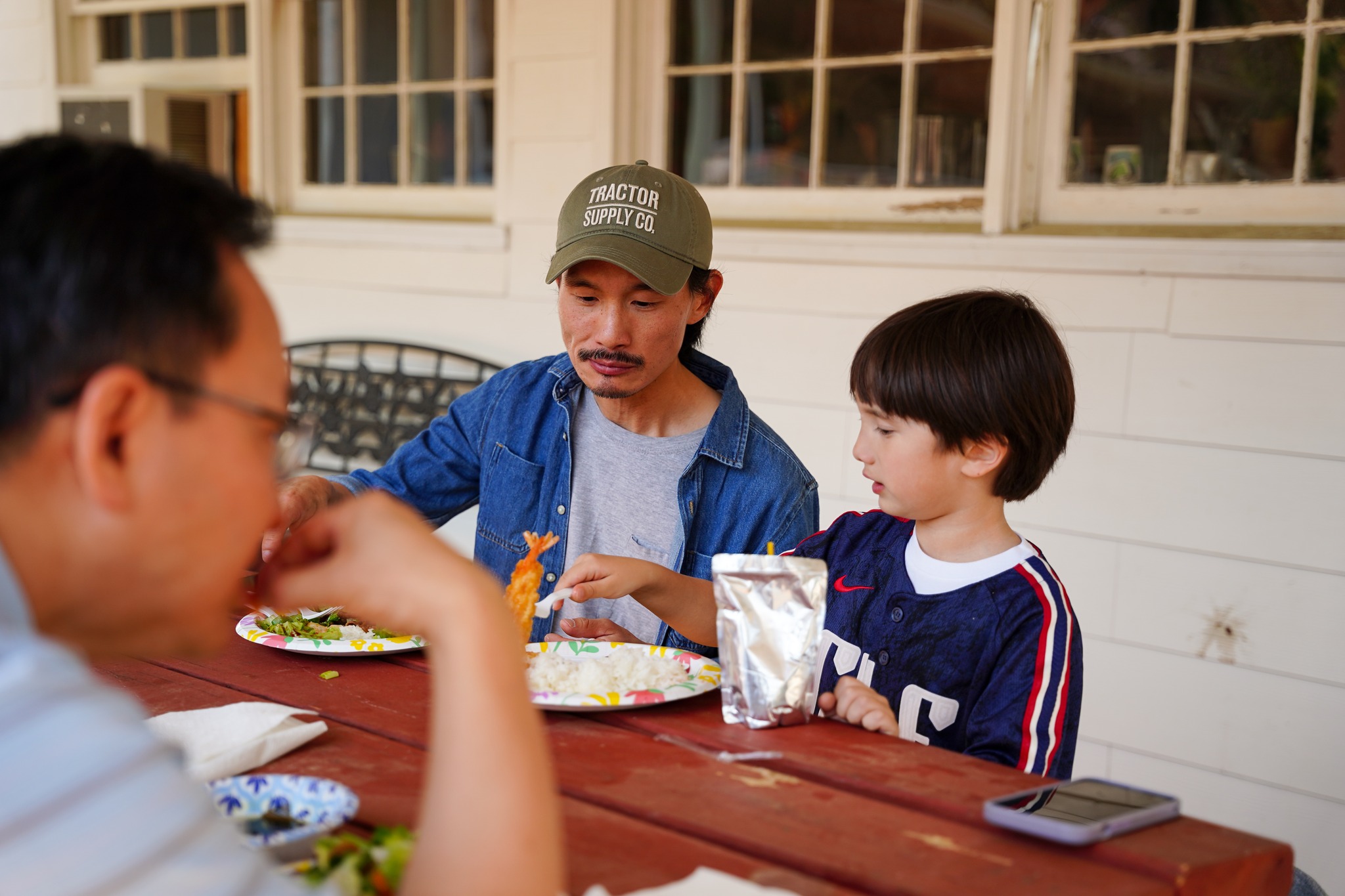 Father and son sharing a meal outdoors